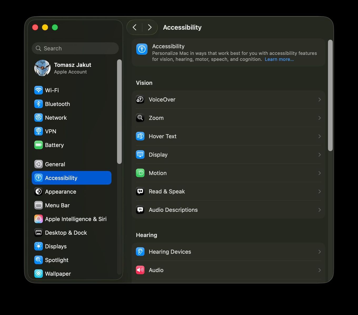 Aplikacja Ustawienia, zakładka "Accessibility"; w sekcji "Vision" znajdują się opcje "VoiceOver", "Zoom", "Hover Text", "Display", "Motion", "Read & Speak", "Audio Descriptions"; w sekcji "Hearing" znajdują się opcje "Hearing Devices" oraz "Audio"; więcej opcji jest niewidocznych.